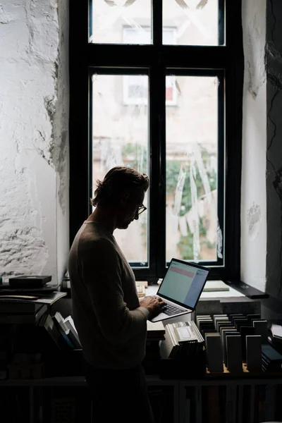 现代写字楼靠窗时使用笔记本电脑的中年白人 — 图库照片