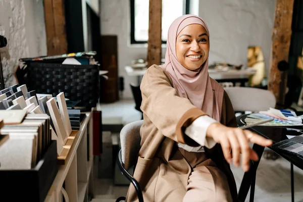 Veselý Arabský Návrhářka Nosit Hidžáb Ukazující Prstem Zatímco Sedí Dílně — Stock fotografie