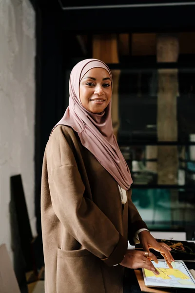 stock image Female muslim designer wearing hijab working on tablet at workshop