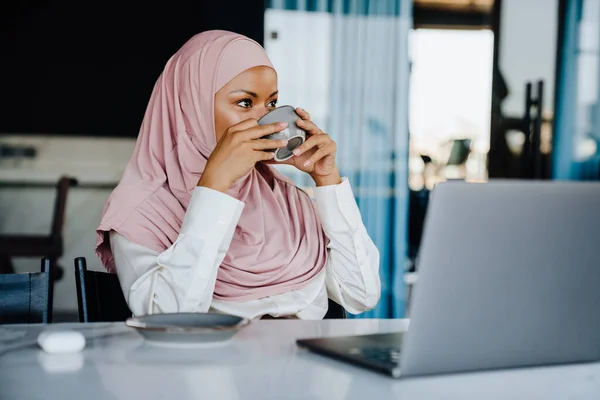Muslimská Mladá Podnikatelka Pije Kávu Zatímco Pracuje Notebooku Kanceláři — Stock fotografie