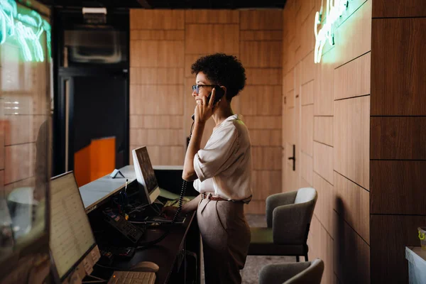 中年快乐的女商人在接待处工作时通电话 — 图库照片