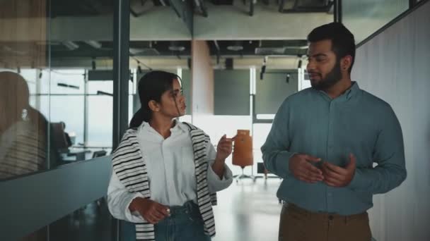 オフィスを歩きながら仕事の話をする集中インド人の同僚 — ストック動画