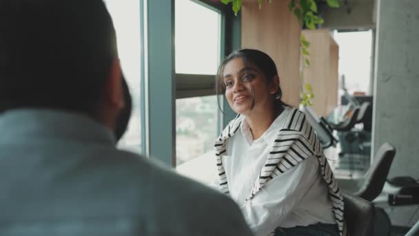 フレンドリーなインド人女性議論何かと彼女の同僚と近くのウィンドウでオフィス — ストック動画