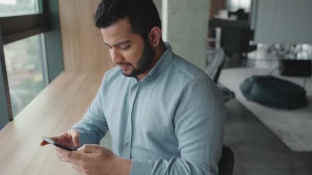 Confident Indian Man Texting Mobile Window Office — Stock Video
