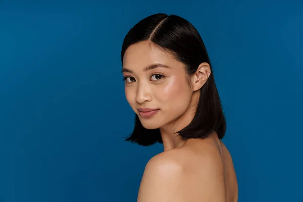 stock image Portrait of young beautiful attractive calm asian woman, while standing over isolated blue background