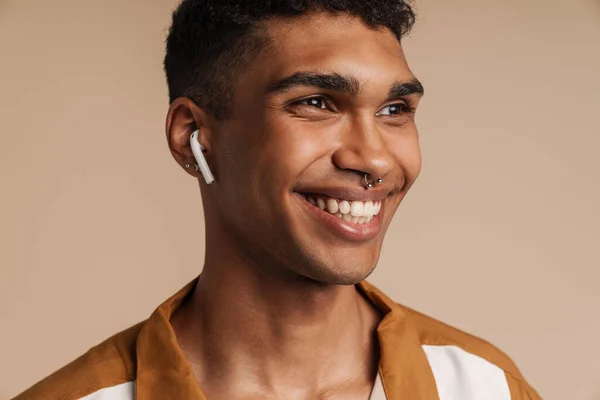 Portret Młodego Przystojnego Uśmiechniętego Afrykanina Słuchawkach Bezprzewodowych Spoglądającego Bok Stojącego — Zdjęcie stockowe
