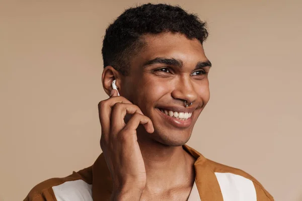 Retrato Joven Guapo Sonriente Hombre Africano Con Auriculares Inalámbricos Tocándolos — Foto de Stock