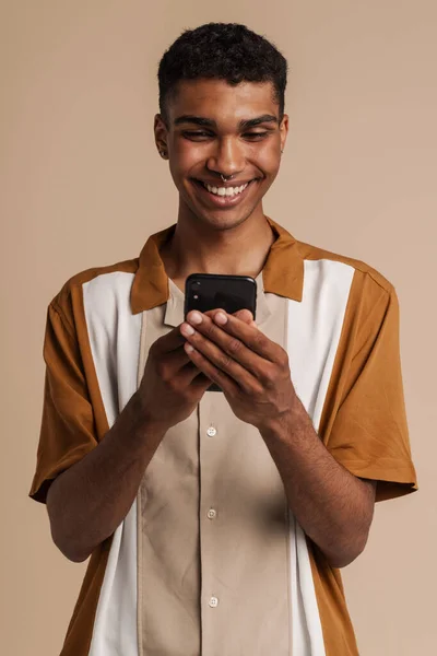 Jonge Afrikaanse Knappe Glimlachende Man Die Telefoon Vasthoudt Gebruikt Terwijl — Stockfoto