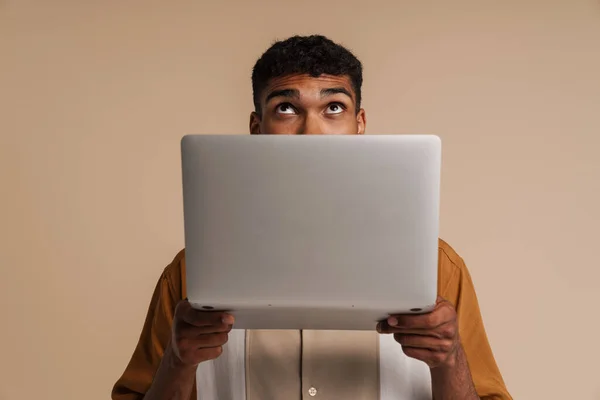 Fiatal Jóképű Afrikai Férfi Kukucskál Laptop Mögül Felfelé Miközben Áll — Stock Fotó