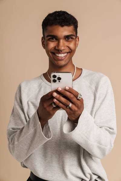 Joven Hombre Negro Con Piercing Sonriendo Mientras Utiliza Teléfono Móvil — Foto de Stock