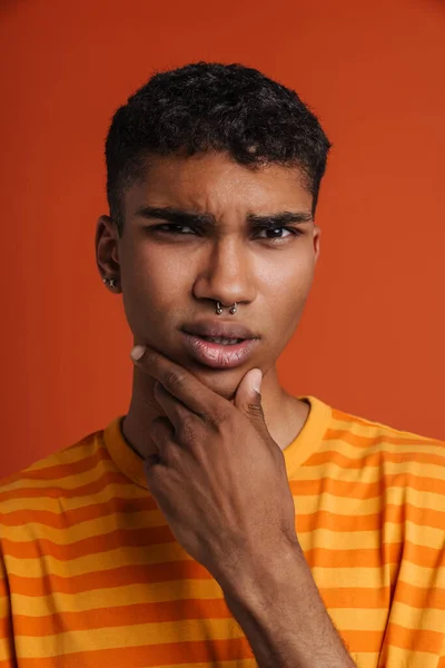 Jovem Negro Com Piercing Franzindo Testa Segurando Seu Queixo Isolado — Fotografia de Stock