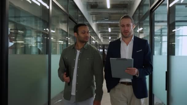オフィスを歩いている間に話している多国籍の深刻な男性の同僚 — ストック動画
