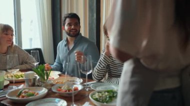 Gülümseyen çok uluslu arkadaşlar doğum günü partisini kutluyorlar kafede garsona sipariş veriyorlar.