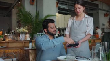 Şirin Hintli doğum günü erkeği, arkadaşlarıyla kafeteryada parti için garsona kartla ödeme yapıyor.