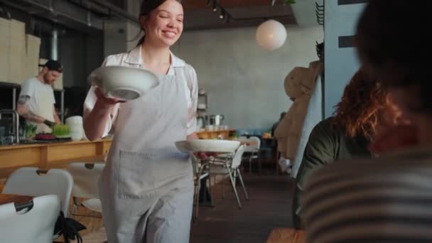 Улыбающийся Официант Приносит Еду Многонациональным Друзьям Празднующим День Рождения Кафе — стоковое видео