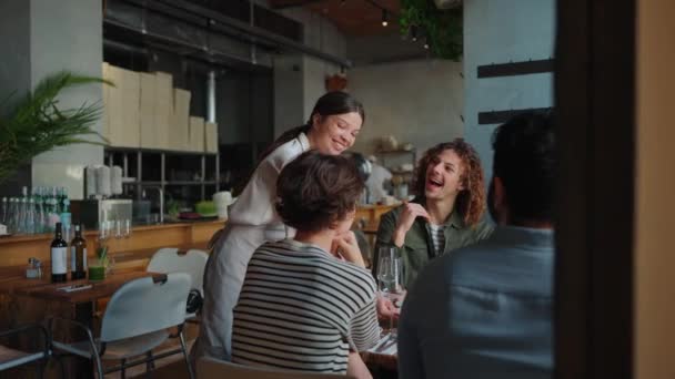 Aranyos Pincér Hoz Ételt Multinacionális Barátoknak Akik Születésnapjukat Kávézóban Ünneplik — Stock videók