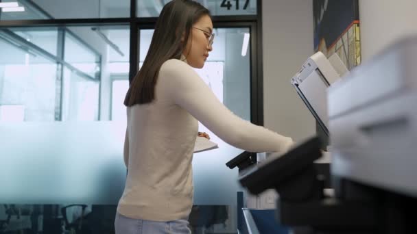 Knappe Aziatische Vrouw Met Een Bril Print Documenten Printer Kantoor — Stockvideo