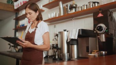 Ciddi yaşlı kadın kahveci kafede kağıt imzaladı.