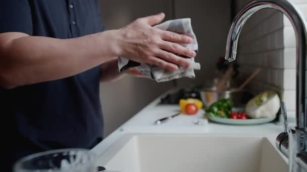 Крупный План Человека Вытирает Руки После Мытья Посуды Кухне Дома — стоковое видео