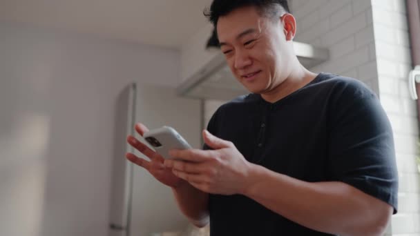 Wesoły Azjatycki Mężczyzna Telefon Komórkowy Kuchni Domu — Wideo stockowe