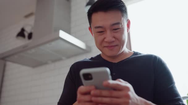 Mutfakta Cep Telefonundan Mesaj Atan Pozitif Asyalı Bir Adam — Stok video