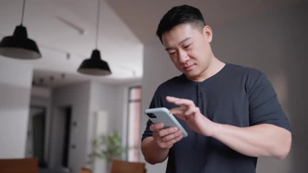 Evdeki Mutfakta Cep Telefonuyla Mesaj Atan Düşünceli Asyalı Adam — Stok video