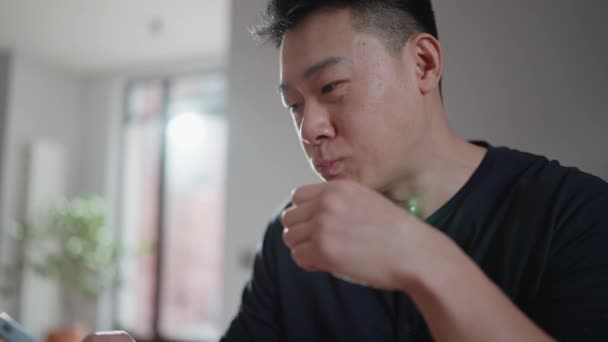 可爱的亚洲男人在家里吃三明治 在早餐时打电话 — 图库视频影像