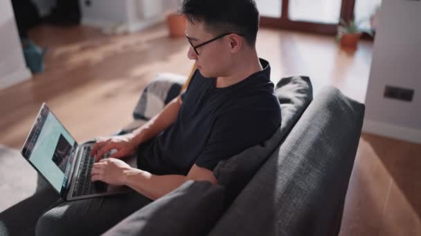 Poważny Azjatycki Inwestor Handlowy Okularach Pracujących Laptopie Telefonie Domu — Wideo stockowe
