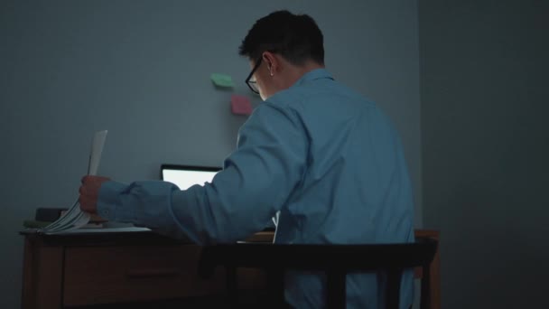 Koncentreret Asiatisk Mand Der Arbejder Med Dokumenter Bærbar Computer Aftenen – Stock-video