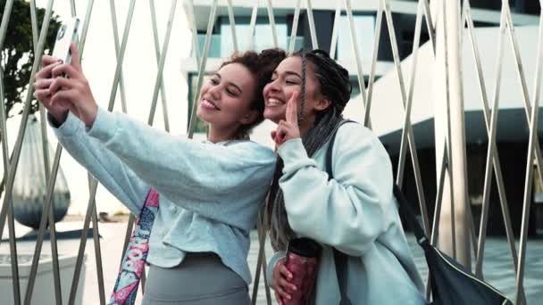 Två Positiva Multinationella Kvinnor Som Tar Selfies Telefon Och Poserar — Stockvideo