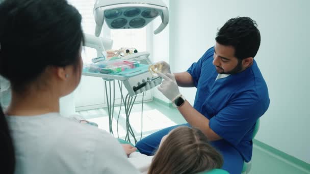 正のインドの歯科医の男性は 病院で口の中の歯の患者構造と位置を示しています 歯医者の予約 — ストック動画