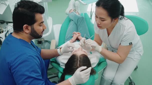 Konzentrierte Asiatische Zahnärztin Bei Der Untersuchung Der Mundhöhle Einer Patientin — Stockvideo