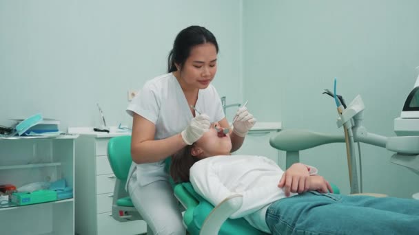 Umfassende Asiatische Zahnärztin Die Krankenhaus Die Mundhöhle Der Patientin Mit — Stockvideo