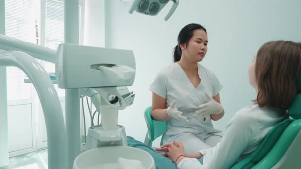 ハンサムなアジアの歯科医の女性は病院の女の子に相談します 医者の予約 — ストック動画