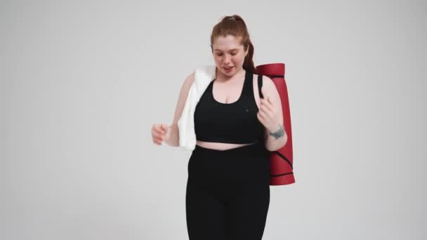Positiv Size Rødhårede Kvinde Sort Træningsdragt Poserende Kamera Med Håndklæde – Stock-video