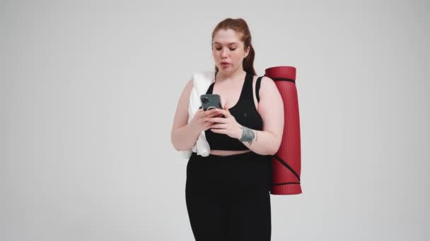 Pensive Size Rudowłosa Kobieta Czarnym Dresie Smsowanie Telefon Ręcznikiem Maty — Wideo stockowe