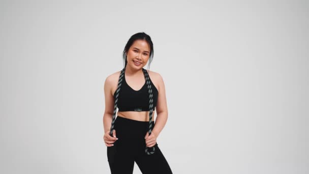 Stilig Asiatisk Kvinna Som Håller Hopprep Svart Träningsoverall Mot Grå — Stockvideo