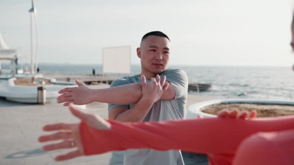 Мила Багатонаціональна Пара Розтягує Руки Морем Світанку — стокове відео