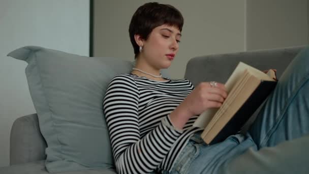 Młoda Piękna Kobieta Kolczykami Czytająca Książkę Kanapie Domu — Wideo stockowe