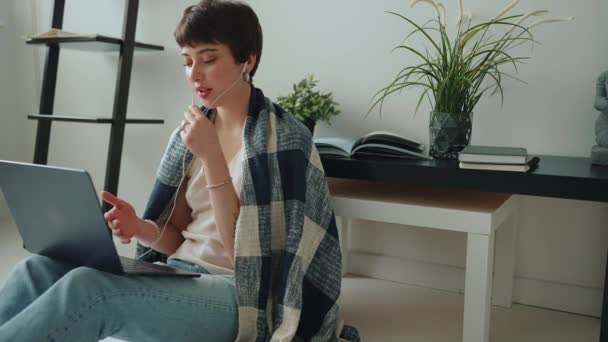 Piercingli Battaniyeye Sarılı Kulaklıklı Laptopla Konuşan Olumlu Bir Kadın — Stok video