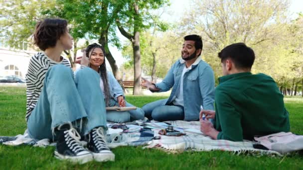 幸せな多民族の友人は公園でのピクニックで英会話クラブで英語を学ぶ — ストック動画