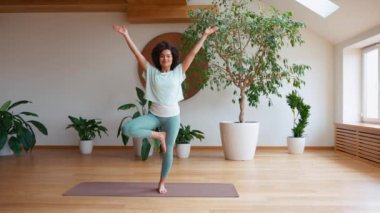 Şirin Afrikalı kıvırcık saçlı kadın evde yoga yapıyor. Sağlıklı bir yaşam tarzı. Spor.