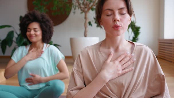 Lächelnde Brünette Trainerin Meditiert Mit Afrikanerin Und Atmet Auf Yogamatte — Stockvideo