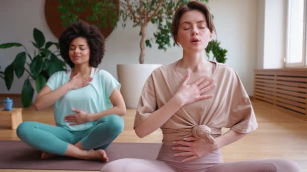 Mujer Entrenadora Morena Meditando Con Mujer Africana Respirando Esterilla Yoga — Vídeos de Stock