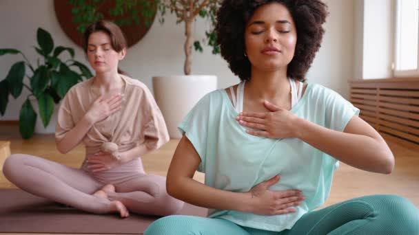 Entrenador Morena Meditando Con Mujer Africana Feliz Respirando Esterilla Yoga — Vídeo de stock