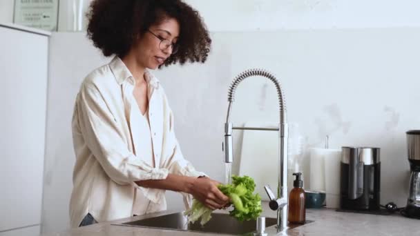 Femeie Destul Africană Ochelari Spălat Frunze Salată Chiuveta Bucătărie Acasă — Videoclip de stoc