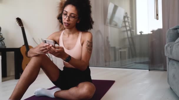积极的非洲女人在手机上发短信 在家里用腕表查看时间 — 图库视频影像