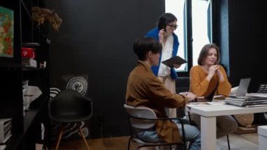 Çok uluslu meslektaş tasarımcılar birlikte çalışma alanındaki dizüstü bilgisayarlarda çalışmayı tartıştılar