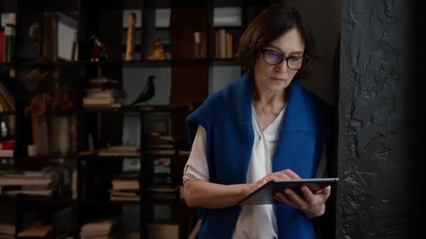 Desainer Wanita Dewasa Terkonsentrasi Dalam Kacamata Yang Bekerja Pada Tablet — Stok Video