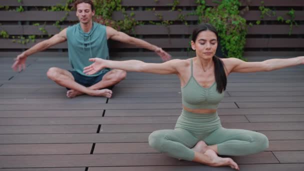 Confident Couple Athletes Meditating Yoga Mat Closed Eyes Hotel Balcony — стоковое видео